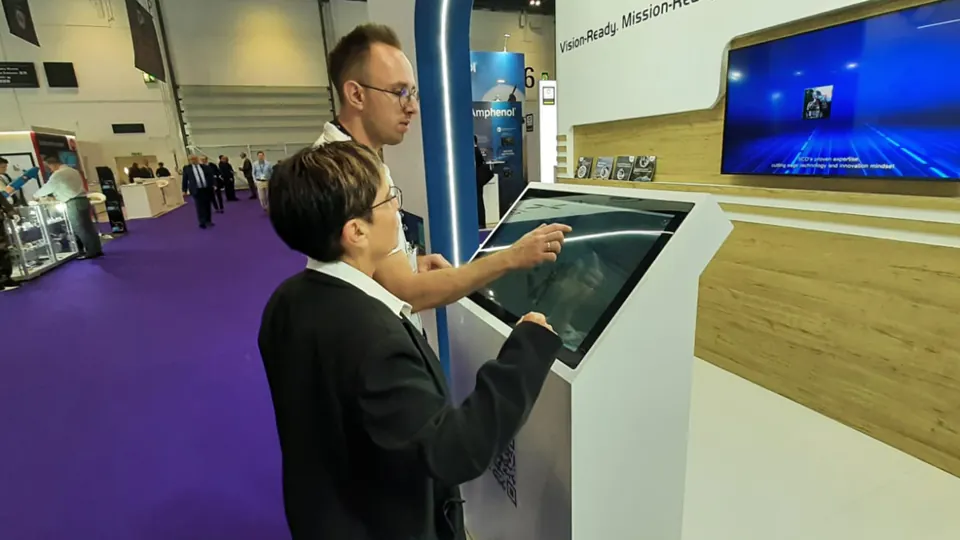 Hands-on demonstration - A visitor uses a touch console beside the main display.